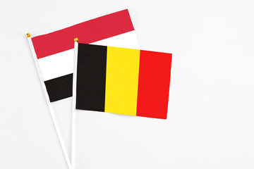 Belgium and Yemen stick flags on white background. High quality fabric, miniature national flag. Peaceful global concept.White floor for copy space.