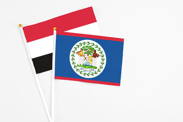 Belize and Yemen stick flags on white background. High quality fabric, miniature national flag. Peaceful global concept.White floor for copy space.