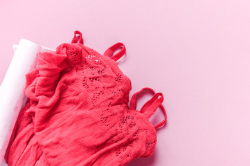 Erotic costume of red color in a mesh. Pink background.