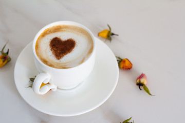 white cup with coffee and cinnamon closeup