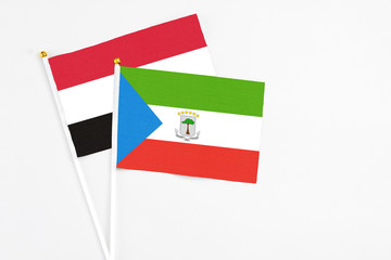 Equatorial Guinea and Yemen stick flags on white background. High quality fabric, miniature national flag. Peaceful global concept.White floor for copy space.