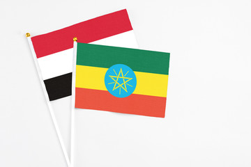 Ethiopia and Yemen stick flags on white background. High quality fabric, miniature national flag. Peaceful global concept.White floor for copy space.