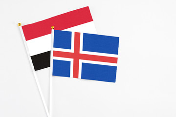 Iceland and Yemen stick flags on white background. High quality fabric, miniature national flag. Peaceful global concept.White floor for copy space.