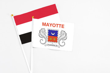 Mayotte and Yemen stick flags on white background. High quality fabric, miniature national flag. Peaceful global concept.White floor for copy space.