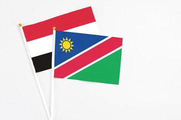 Namibia and Yemen stick flags on white background. High quality fabric, miniature national flag. Peaceful global concept.White floor for copy space.