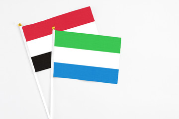 Sierra Leone and Yemen stick flags on white background. High quality fabric, miniature national flag. Peaceful global concept.White floor for copy space.