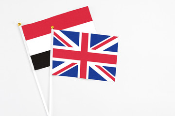 United Kingdom and Yemen stick flags on white background. High quality fabric, miniature national flag. Peaceful global concept.White floor for copy space.