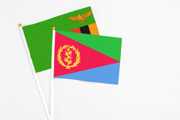 Eritrea and Zambia stick flags on white background. High quality fabric, miniature national flag. Peaceful global concept.White floor for copy space.