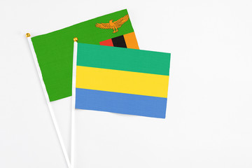 Gabon and Zambia stick flags on white background. High quality fabric, miniature national flag....
