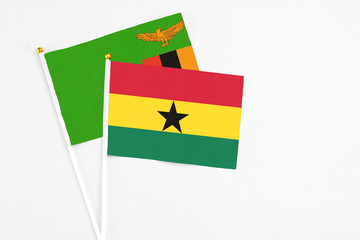 Ghana and Zambia stick flags on white background. High quality fabric, miniature national flag. Peaceful global concept.White floor for copy space.