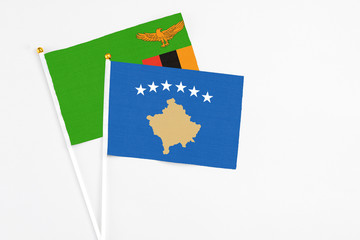 Kosovo and Zambia stick flags on white background. High quality fabric, miniature national flag. Peaceful global concept.White floor for copy space.