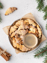 Homemade christmas croissants  (crescent rolls) on a wooden tray with fir tree branches and...