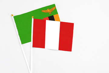 Peru and Zambia stick flags on white background. High quality fabric, miniature national flag. Peaceful global concept.White floor for copy space.