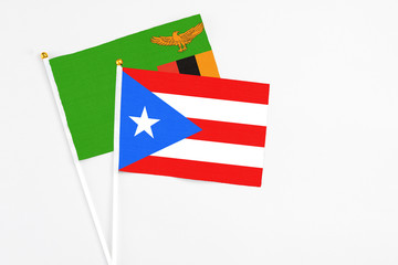 Puerto Rico and Zambia stick flags on white background. High quality fabric, miniature national flag. Peaceful global concept.White floor for copy space.