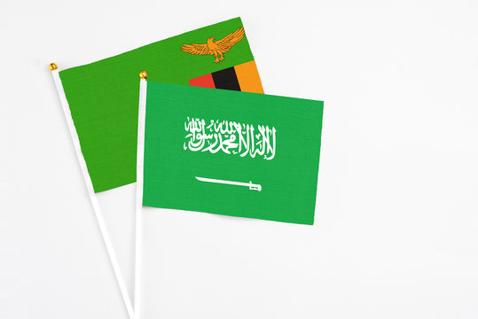 Saudi Arabia and Zambia stick flags on white background. High quality fabric, miniature national flag. Peaceful global concept.White floor for copy space.