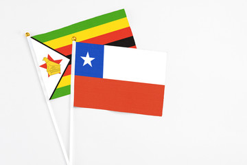 Chile and Zimbabwe stick flags on white background. High quality fabric, miniature national flag. Peaceful global concept.White floor for copy space.