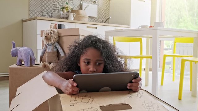 Young girl using tablet computer at kitchen table, front view