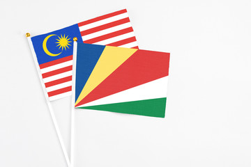 Seychelles and Malaysia stick flags on white background. High quality fabric, miniature national flag. Peaceful global concept.White floor for copy space.
