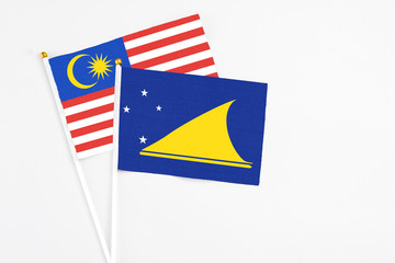 Tokelau and Malaysia stick flags on white background. High quality fabric, miniature national flag. Peaceful global concept.White floor for copy space.