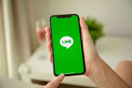 Woman hand holding iPhone X with social networking service Line