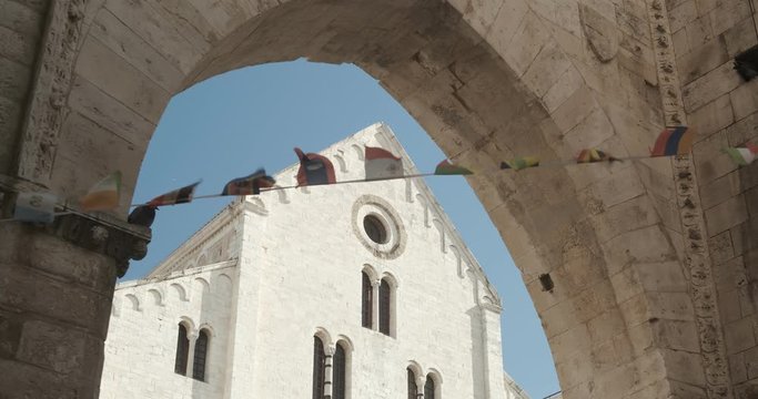 Fa&ccedil;ade of the church of San Nicola in Bari in limestone. Church with light stone walls with the blue sky background with clouds.