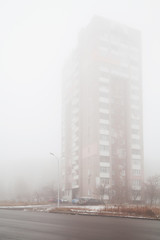 Fototapeta na wymiar Multi-storey residential building in dense fog