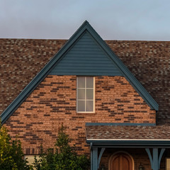 Square House with steeply pitched roof near sunset