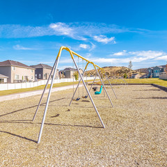 Square frame A-frame swings in a small kids playground