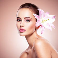 Fototapeta na wymiar Beauty pure face of the young beautiful girl with flower