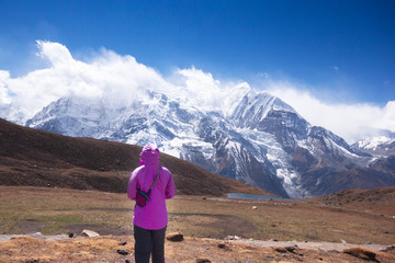 Asian woman trekker in valley of Everest base camp trekking route in Khumbu ,Nepal with snow mountain in background.