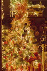 Closeup of white bauble hanging from decorated Christmas tree with bokeh, copy space, Christmas...