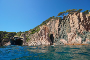 Rocky coastal cliff with a boat seen from sea surface, Spain, Mediterranean, Costa Brava, Catalonia, Aigua Xelida, Palafrugell