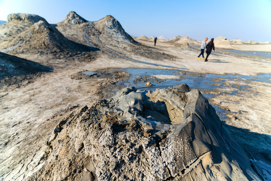 Mud volcano with tourist in background in gobustan national park ,Azerbaijan.Bubbling crater of a mud volcano.