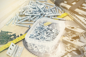 Screws, confirmations for furniture, tape measure, lie on the table. Furniture production