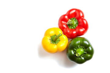 Red, green, and yellow bell peppers isolated on white background with copy space. Sweet peppers in different colors, vegetable ingredient, healthy food