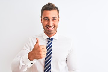 Young handsome elegant business man over isolated background doing happy thumbs up gesture with hand. Approving expression looking at the camera showing success.