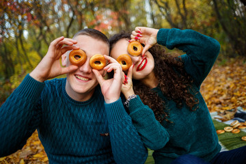 A guy and a girl in the autumn forest with cookies