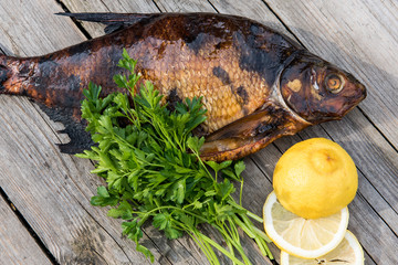 fish with lemon and greens on grey wooden boards