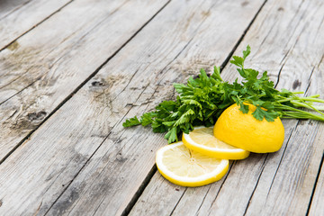 lemon and a bunch of greens on wooden gray boards