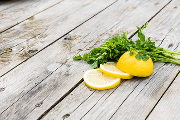 lemon and a bunch of greens on wooden gray boards