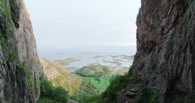 Wide drone shot with forward motion of the scenic ocean view from a natural glacial made tunnel through the popular mountain and tourist attraction Torghatten, in Br&oslash;nn&oslash;ysund Helgeland Norway.