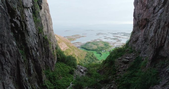 4K wide drone shot with forward tilt motion of the scenic ocean view from a natural glacial made tunnel through the popular mountain and tourist attraction Torghatten, in Br&oslash;nn&oslash;ysund Helgeland Norway.