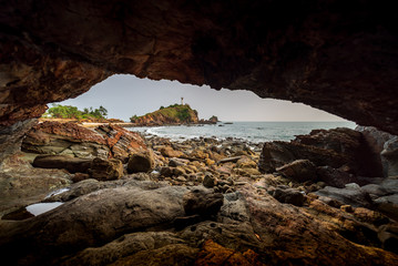 Fototapeta na wymiar The picture taken from small cave at Ko Lanta in Krabi that can see Lighthouse Koh Lanta very small.