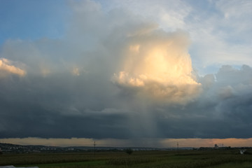 Thunderstorm with clear defined rain shaft and sunlit anvil