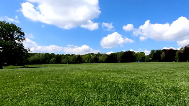 Panning around at a low perspective of the open grass area of the war memorial park in Coventry on a warm spring day