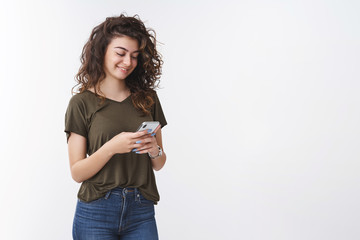 Lovely armenian young happy cute woman curly-haired holding smartphone smiling gently laughing...