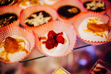 Sweet cream cookies with raspberries closeup of cakes on event or wedding reception