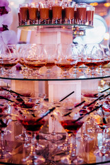View of alcohol setting on catering banquet table, row line of different colored alcohol cocktails on a party, martini, vodka, and others on decorated catering bouquet table event