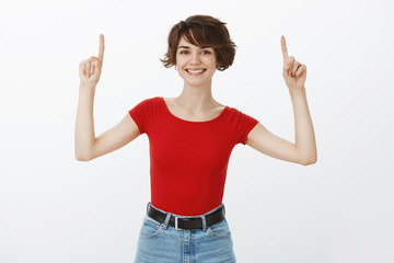 Morivated good-looking energized cheerful woman short haircut raise hands pointing up promote top advertisement smiling broadly introduce amazing opportunity stand white background pleased