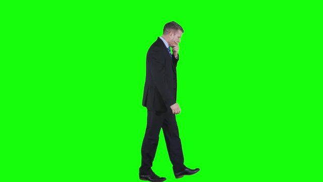 Confused Caucasian businessman thinking something and walking back and forth in the studio. Shot in 4k resolution with green screen background